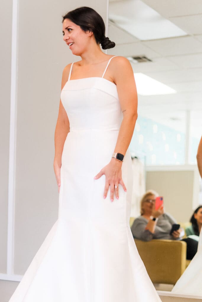 Smiling bride in minimalist strap wedding dress during joyful fitting in Austin bridal boutique with Olive & Eden Weddings