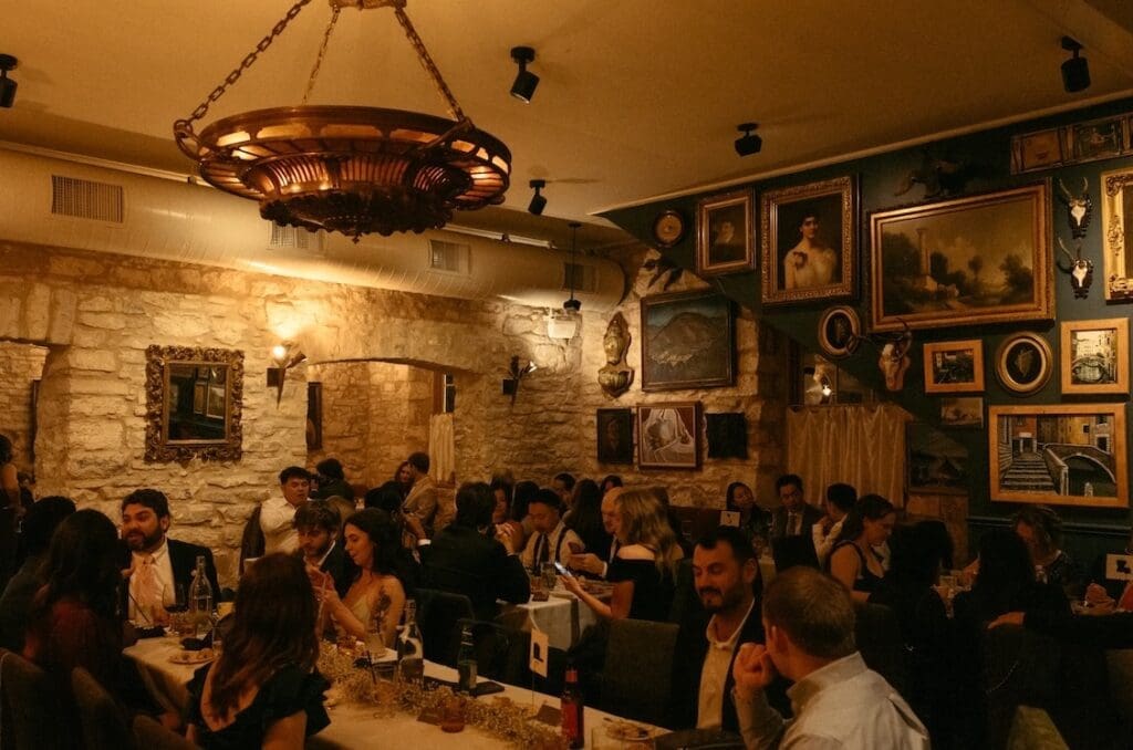 A wide shot of a wedding reception at Alla Campagna in Fredericksburg, featuring original limestone and wood paneling.