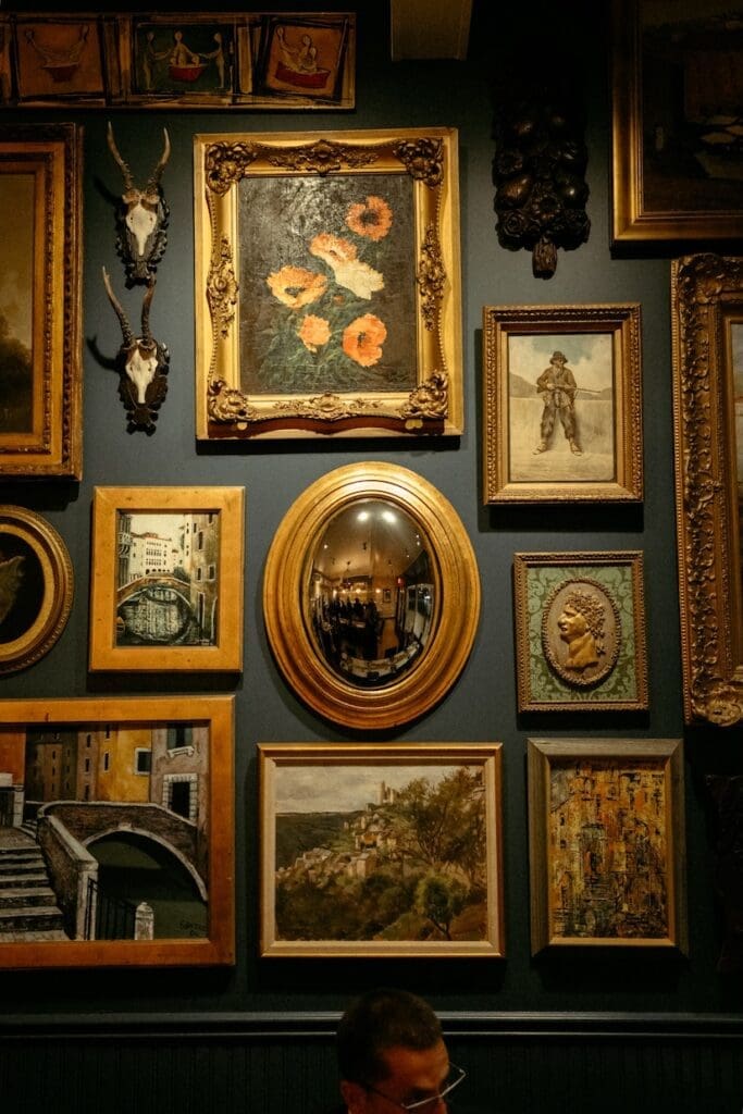 A curated gallery wall of vintage gold frames on a stone wall at a luxury Hill Country wedding.